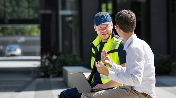 Caverion employee talking with a customer while sitting.jpg